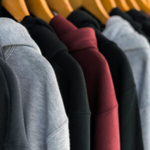 row of fashionable clothing on hangers .